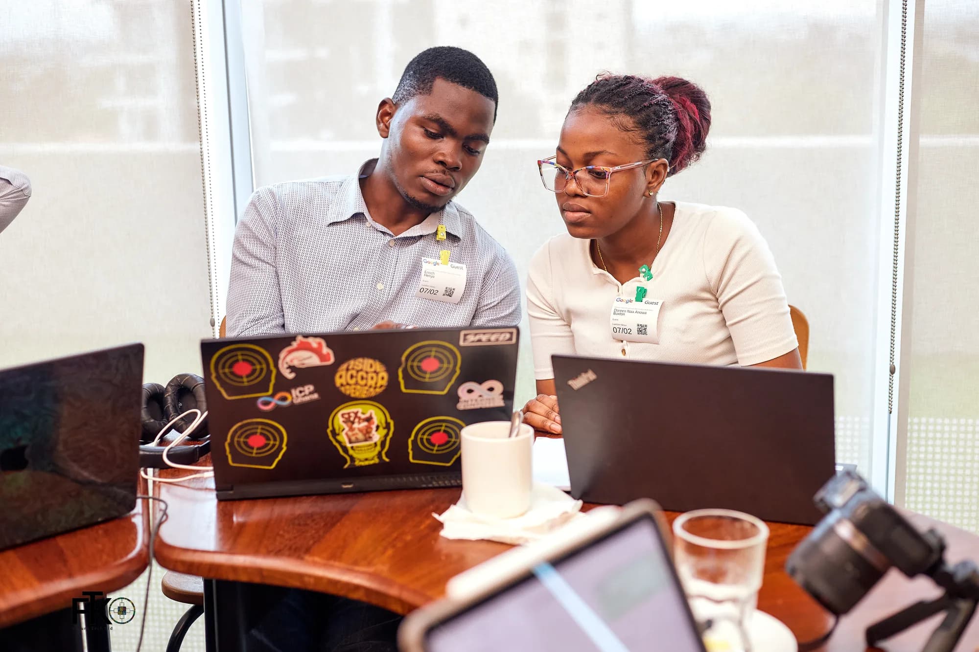 Two participants side by side at their laptops, working through a problem together