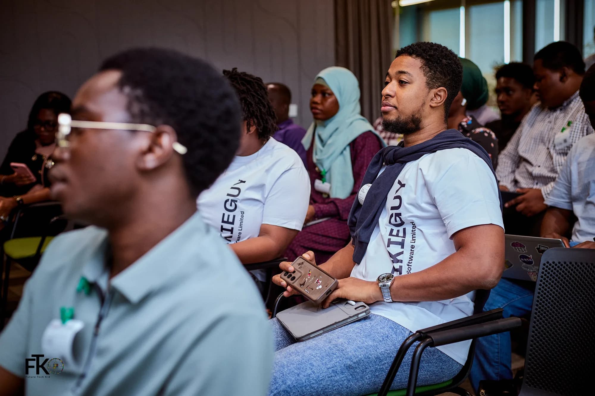 Attendees in Ikieguy shirts seated in the audience during a session